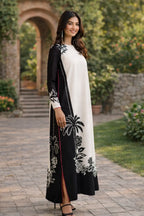 Woman wearing a black and white embroidered dress in an outdoor setting