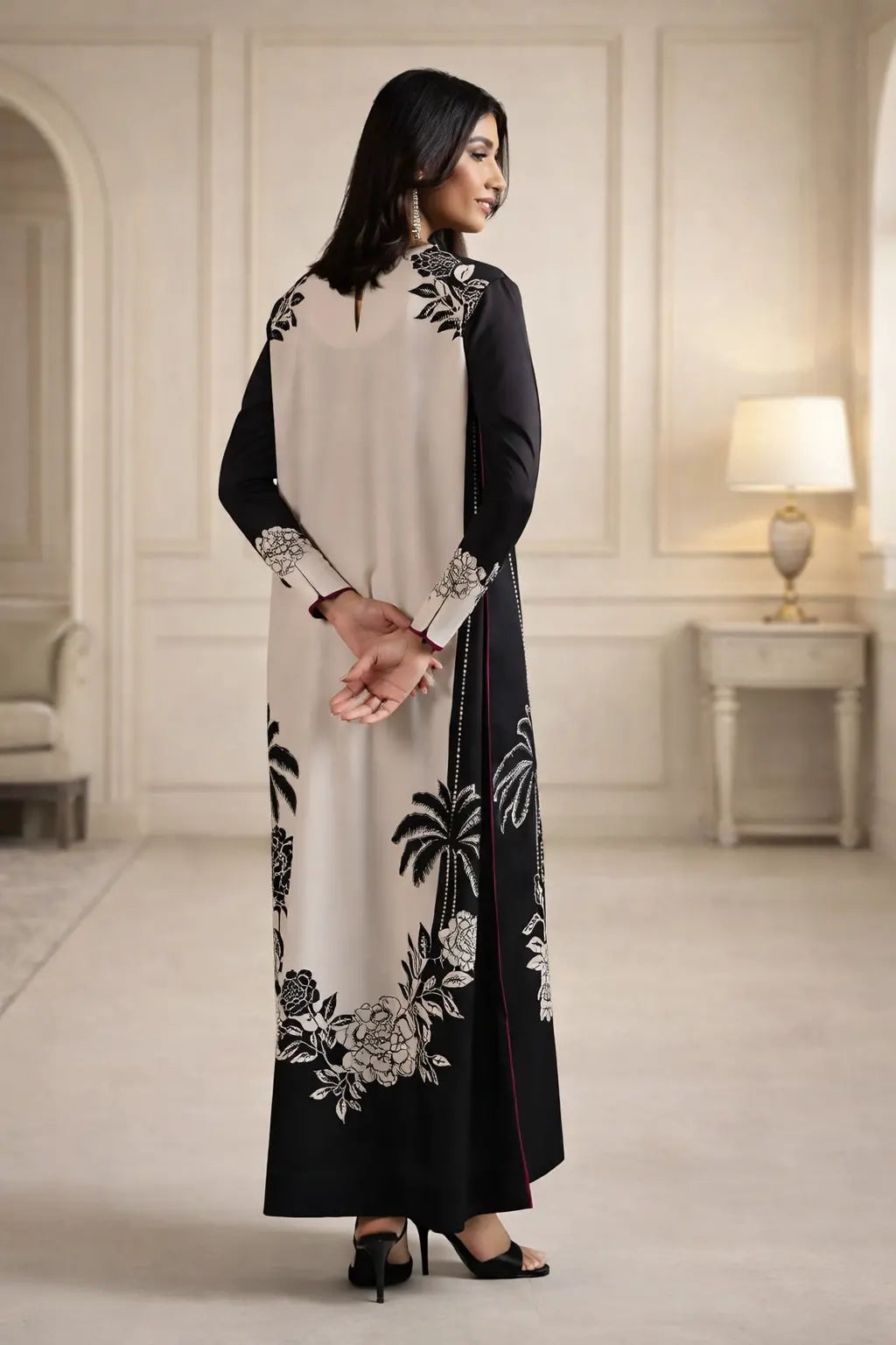 Woman wearing a black and white embroidered dress in an elegant room.
