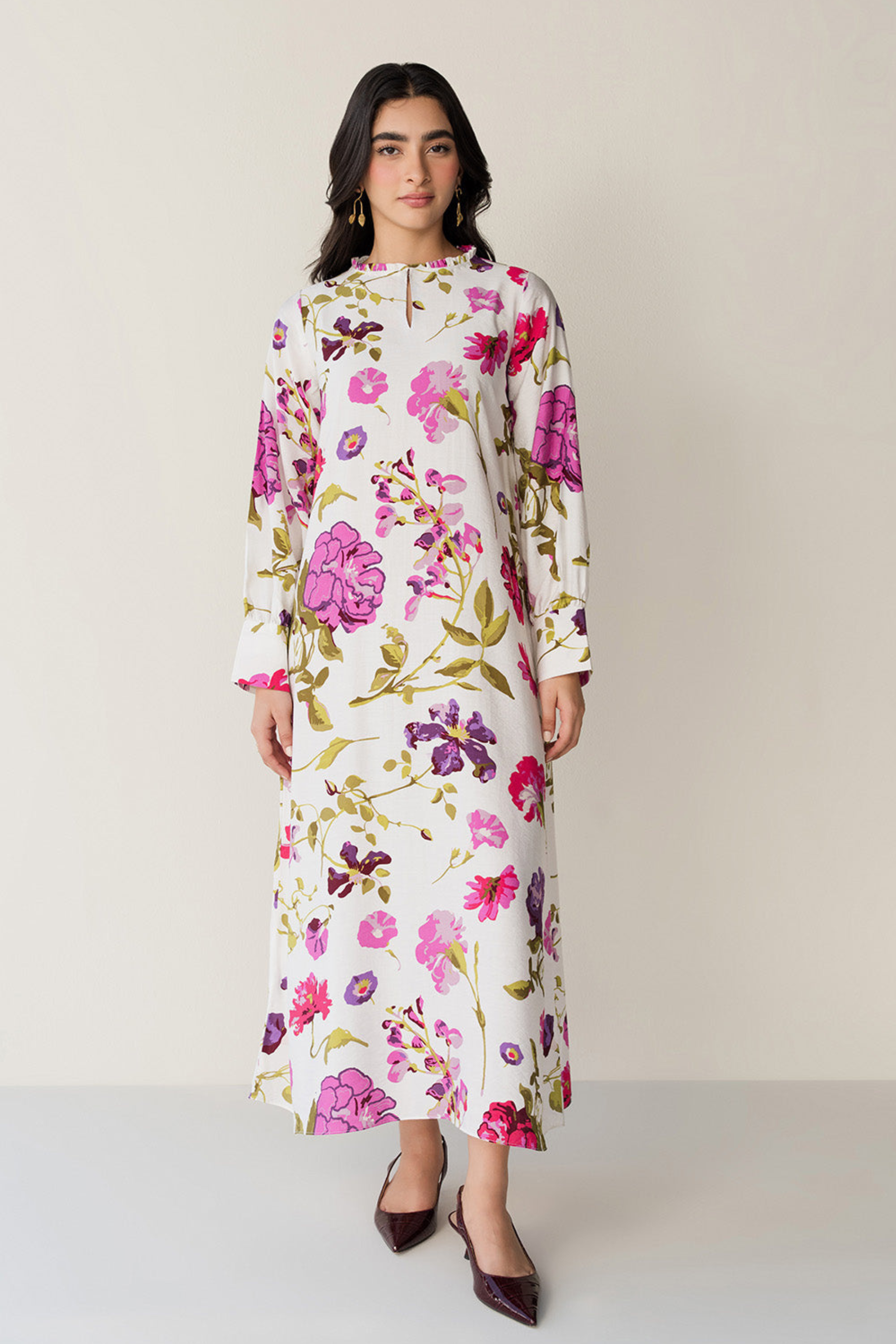 Woman wearing a floral dress against a plain background