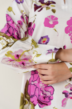 Close-up of a floral-patterned fabric with pink and purple flowers.