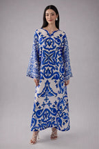 Woman wearing a blue and white patterned dress on a gray background
