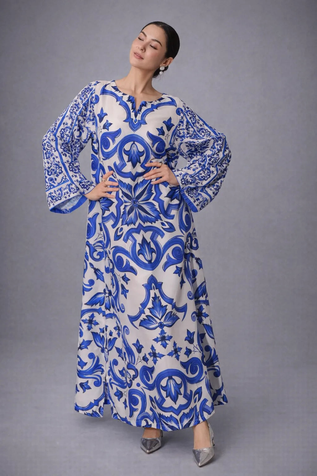 Woman wearing a blue and white patterned dress on a gray background