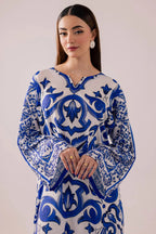 Woman wearing a blue and white patterned dress against a plain background