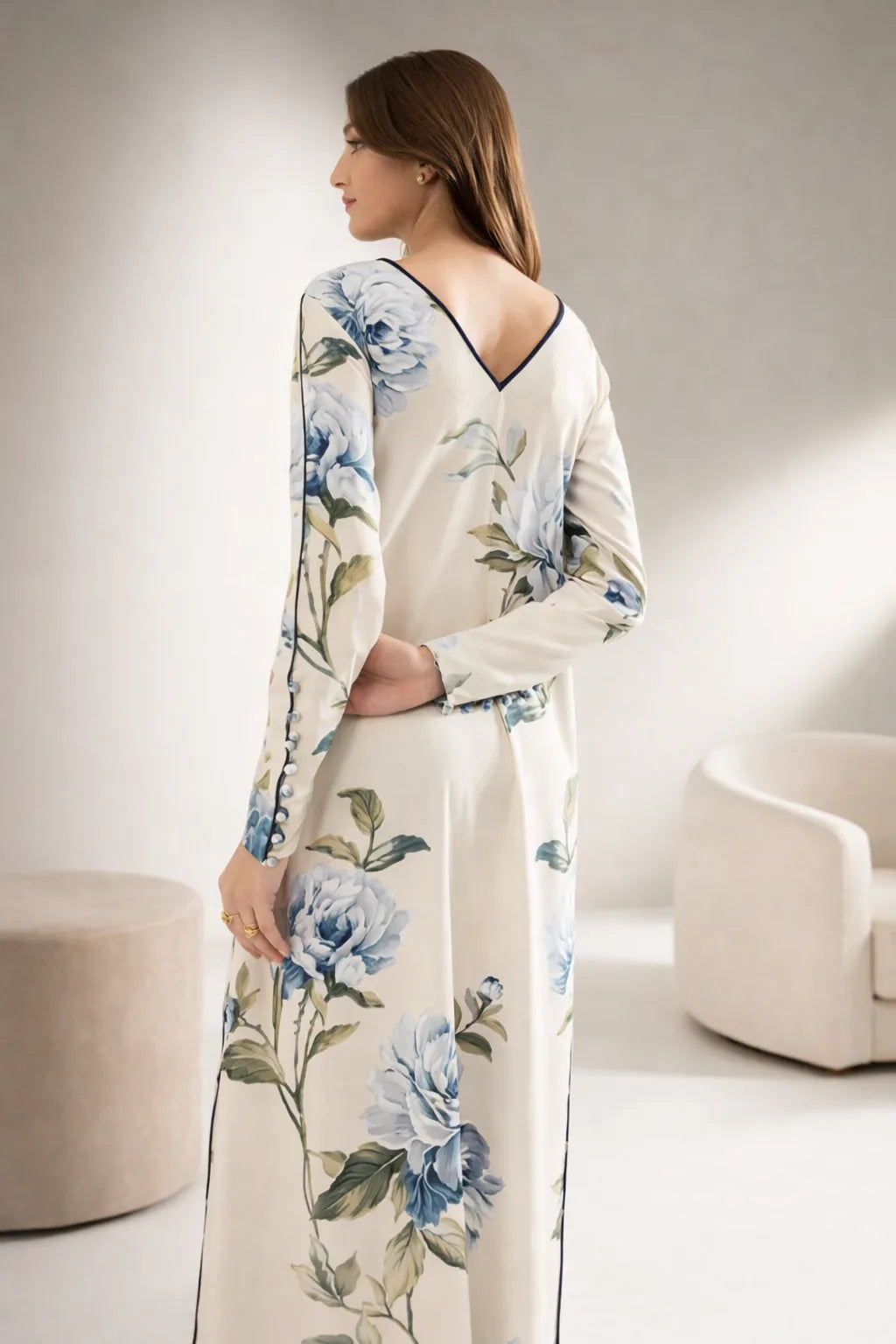 Woman wearing a floral dress in a minimalistic room.