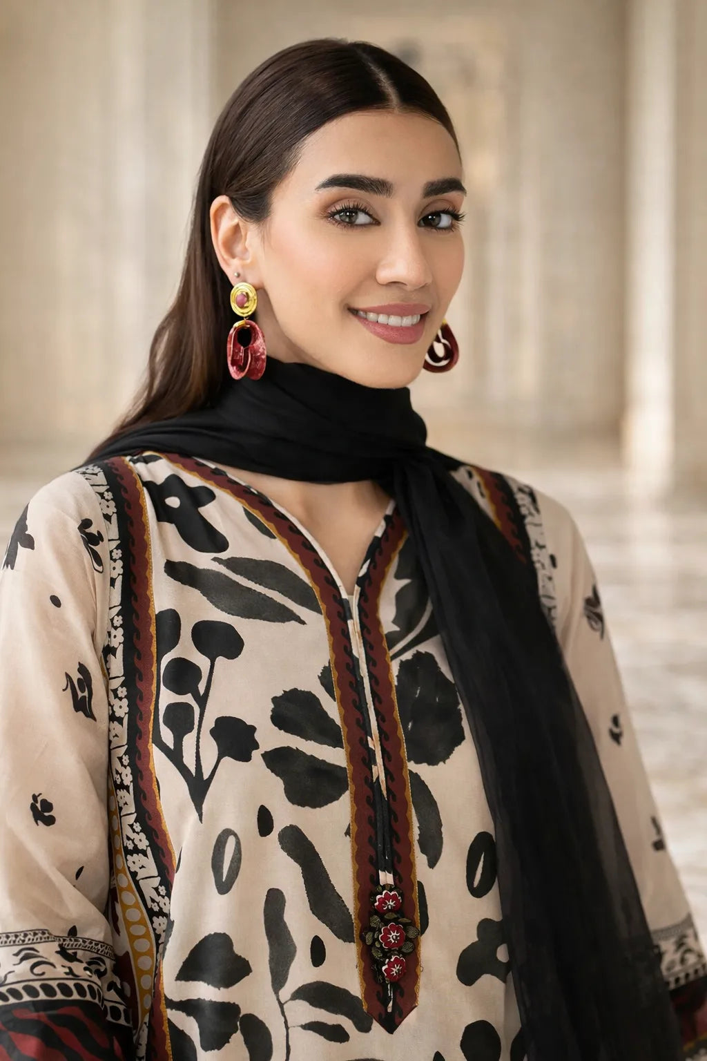 Woman wearing a traditional outfit with intricate patterns and jewelry indoors.