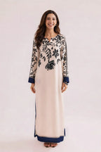 Woman wearing a long, patterned dress with a white background