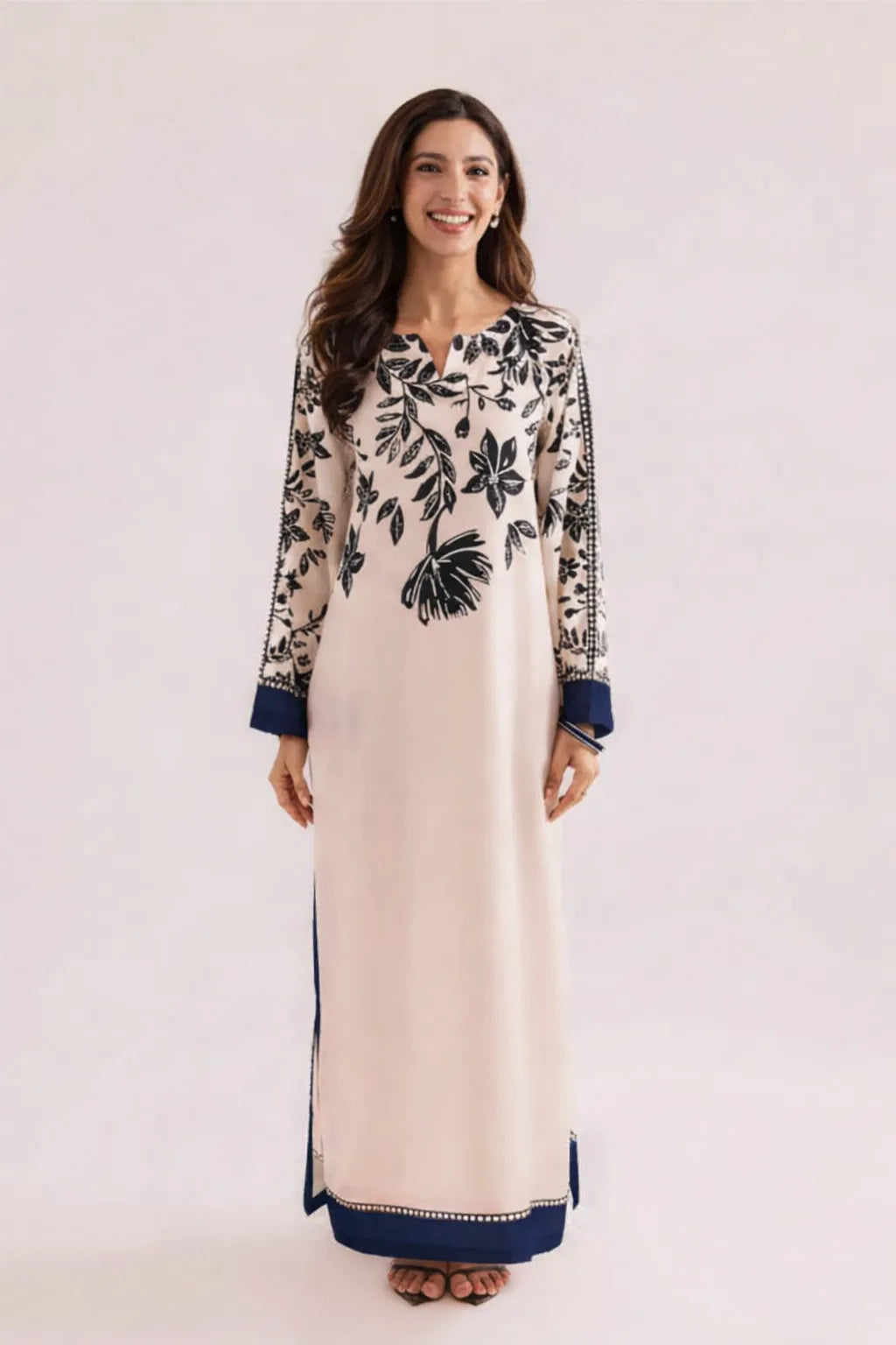Woman wearing a long, patterned dress with a white background