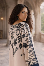 Woman wearing a floral-patterned outfit in an outdoor setting with arches.
