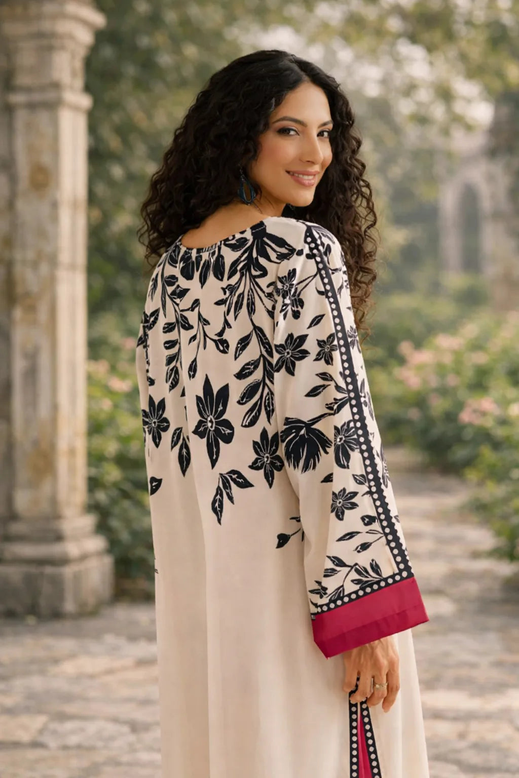 Woman wearing a floral off-shoulder top with a blurred garden background